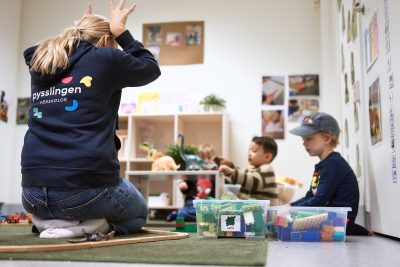 Barn och pedagog bygger tågbana.