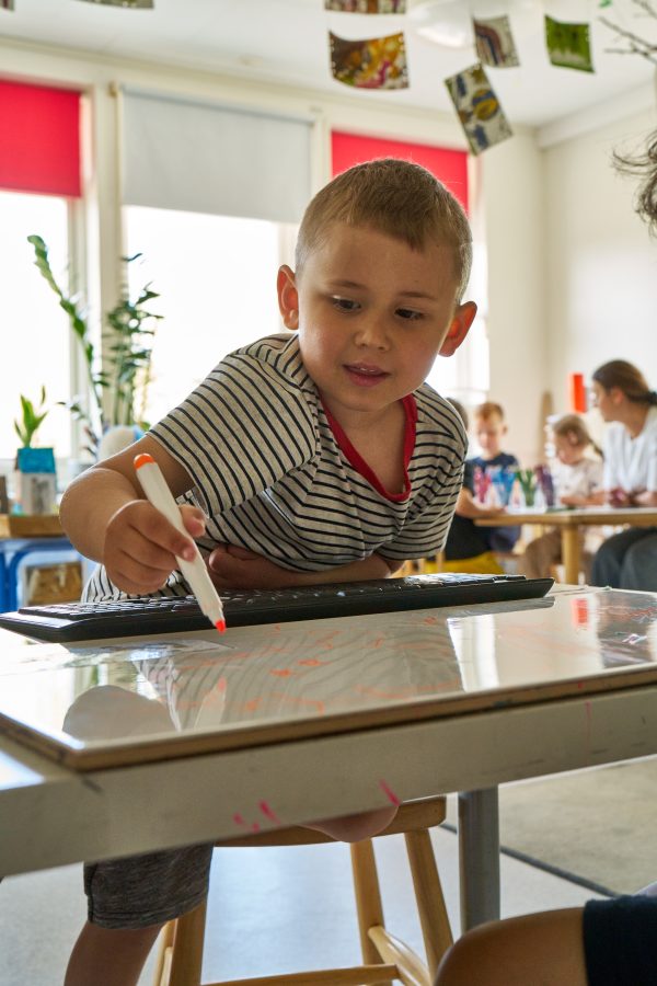 Pojke tecknar på förskolan.
