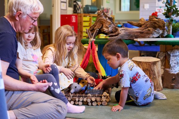 pedagog och barn leker med naturmaterial