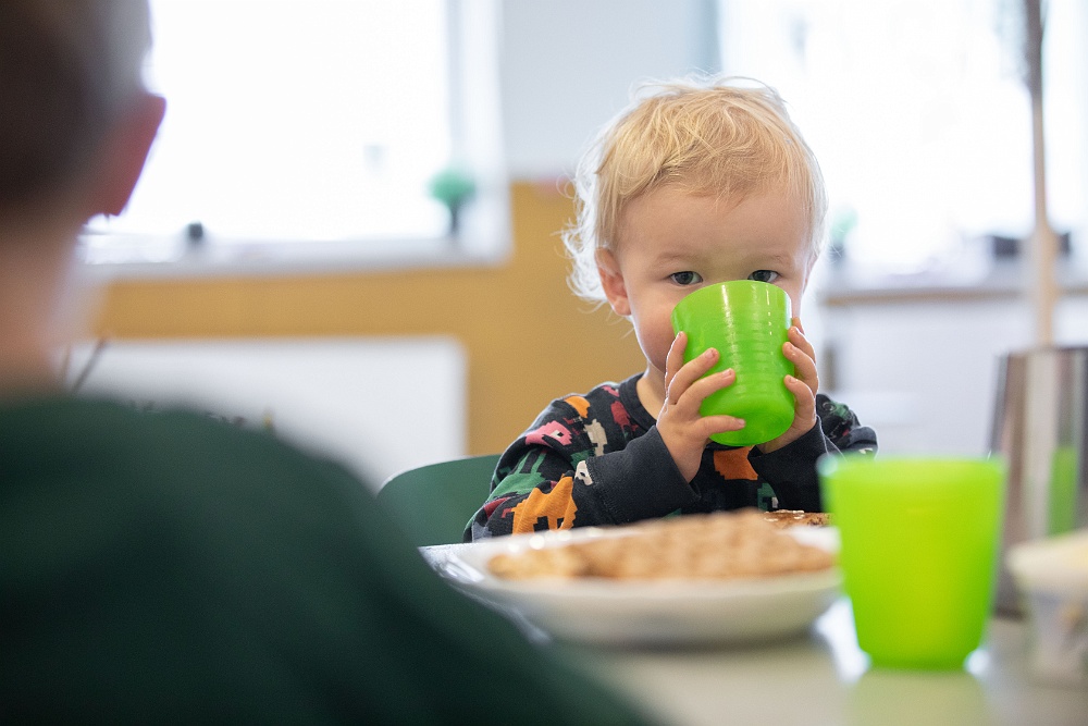 Liten pojke dricker på förskola