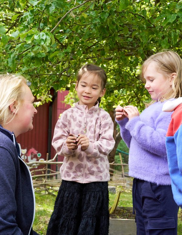 pedagog och barn utforskar tillsammans utomhus