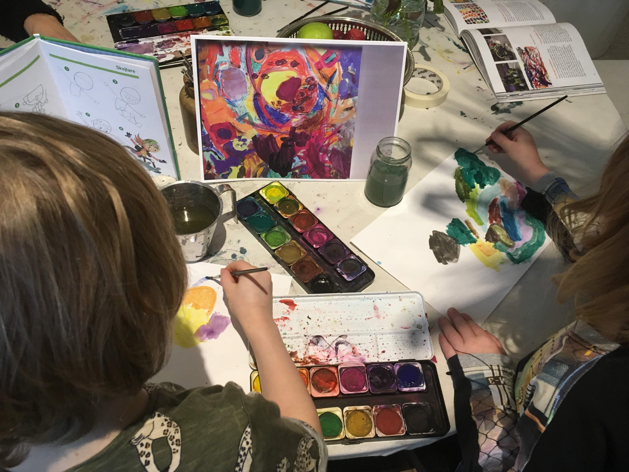 Flera barn målar med färgglada färger på förskolan
