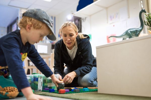 barn och pedagog interagerar och leker på förskolan