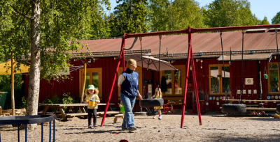 Barn och pedagog leker på utegården.