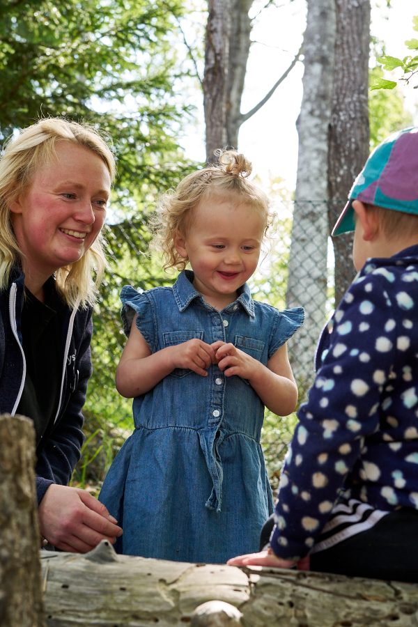 Pedagog och barn upptäcker tillsammans utomhus.