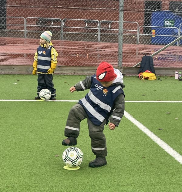Barn spelar fotboll.