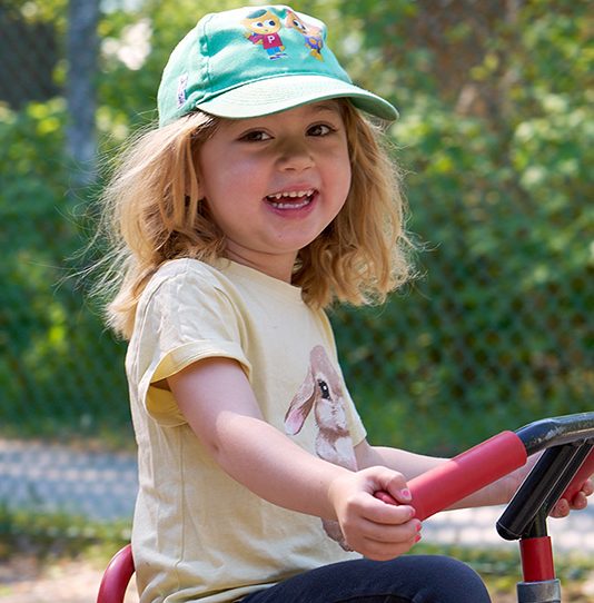 Flicka cyklar på trehjuling