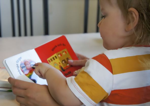 Litet barn läser bok på förskolan