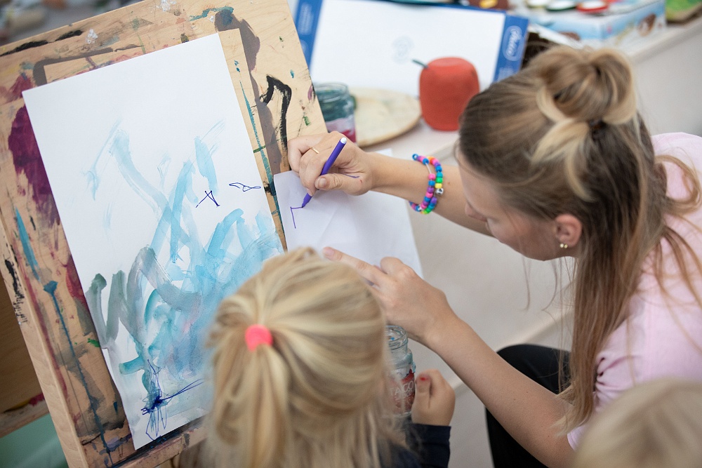 Pedagog målar med barn på förskola