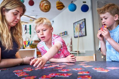 pedagog och barn spelar spel tillsammans på förskolan