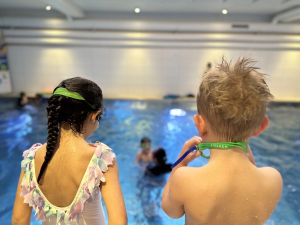 Två barn badar på simskola