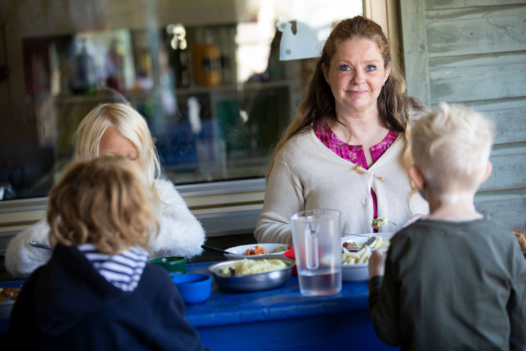 Pedagog på förskola äter med barnen