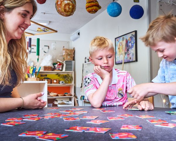 Glad pedagog spelar memory med två barn